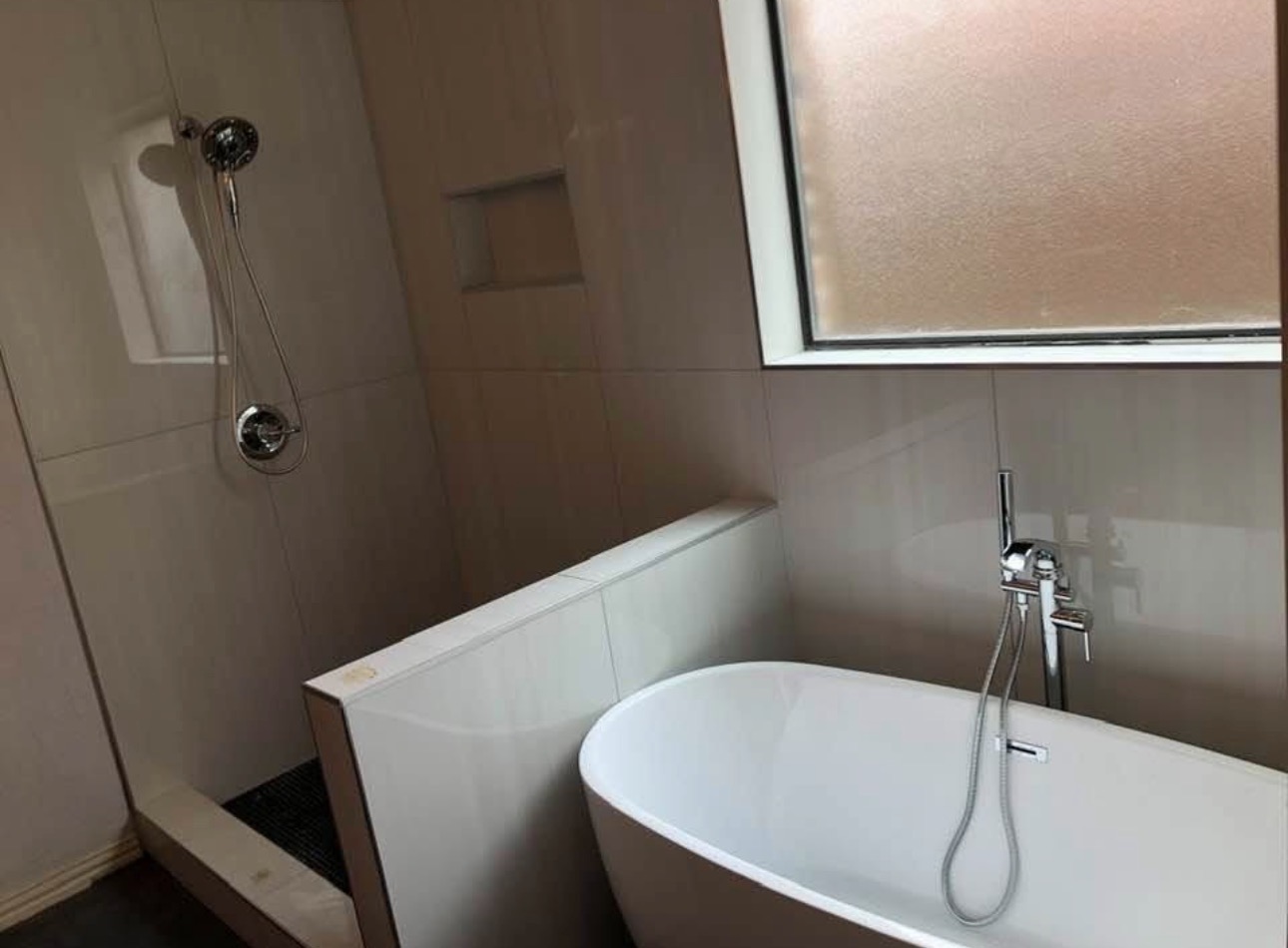 Freestanding soaking tub with large format tile surround and walk-in shower — luxury DFW